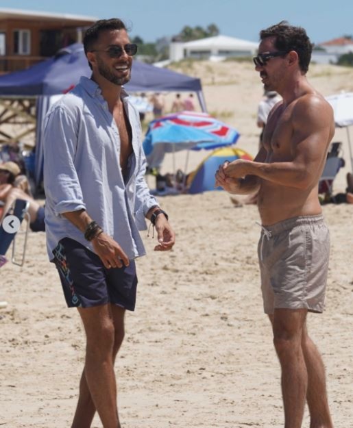 Un ex participante de Gran Hermano camina por la playa de Punta del Este junto a su novio durante una jornada de verano.